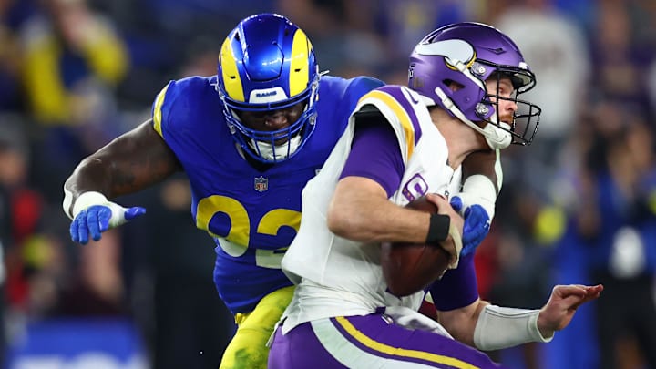 Jan 13, 2025; Glendale, AZ, USA; Minnesota Vikings quarterback Sam Darnold (14) is sacked by Los Angeles Rams defensive tackle Neville Gallimore (92) during the second half in an NFC wild card game at State Farm Stadium.