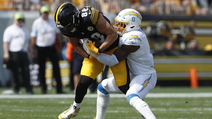 Sep 22, 2024; Pittsburgh, Pennsylvania, USA;  Pittsburgh Steelers tight end Pat Freiermuth (88) runs after a catch as Los Angeles Chargers linebacker Daiyan Henley (0) defends during the second quarter at Acrisure Stadium. Mandatory Credit: Charles LeClaire-Imagn Images