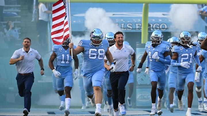 Nov 25, 2022; Chapel Hill, North Carolina, USA; North Carolina Tar Heels offensive lineman Brian Anderson (68) leads teammates carrying the American flag on to the the field at Kenan Memorial Stadium. Mandatory Credit: Bob Donnan-Imagn Images