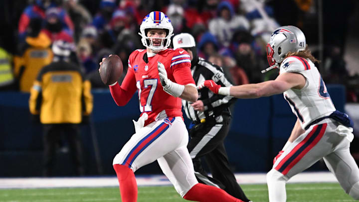 Dec 22, 2024; Orchard Park, New York, USA; Buffalo Bills quarterback Josh Allen (17) looks downfield to throw while avoiding New England Patriots safety Brenden Schooler (41) in the second quarter at Highmark Stadium. 