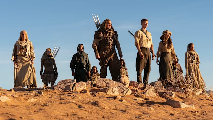 A group of Aiel with Rand (Josha Stradowski), Moiraine (Rosamund Pike) and Lan (Daniel Henney), which includes Bair (Nukâka Coster-Waldau) and Rhuarc (Björn Landberg).