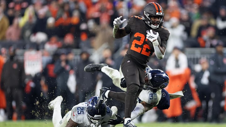 Dec 7, 2025; Cleveland, Ohio, USA; Cleveland Browns running back Dylan Sampson (22) runs the ball for a first down against Tennessee Titans safety Xavier Woods (25) and linebacker Cedric Gray (33) during the fourth quarter at Huntington Bank Field. Mandatory Credit: Scott Galvin-Imagn Images