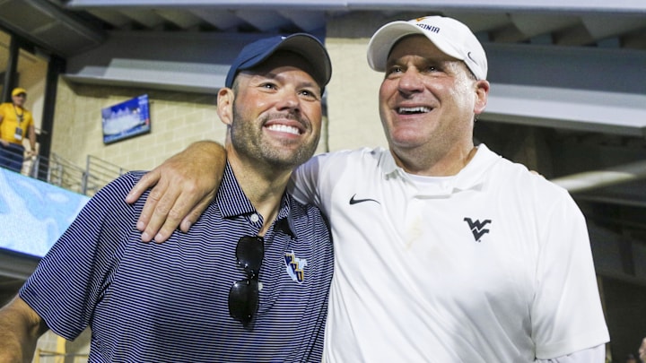 Sep 13, 2025; Morgantown, West Virginia, USA; West Virginia Mountaineers head coach Rich Rodriguez celebrates with West Virginia University athletic director Wren Baker after defeating the Pittsburgh Panthers at Milan Puskar Stadium. Mandatory Credit: Ben Queen-Imagn Images