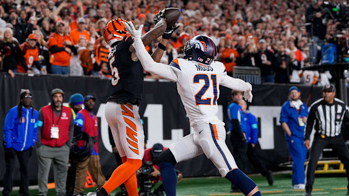 Cincinnati Bengals wide receiver Tee Higgins (5) catches a touchdown pass over Denver Broncos cornerback Riley Moss (21) in the fourth quarter of the NFL Week 17 game between the Cincinnati Bengals and the Denver Broncos at Paycor Stadium in downtown Cincinnati on Saturday, Dec. 28, 2024. The Bengals took a 30-24 win in overtime to remain in the post season chase.