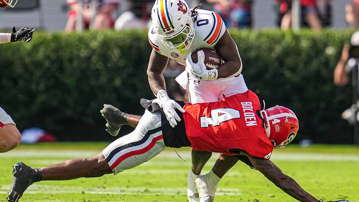 Oct 5, 2024; Athens, Georgia, USA; Auburn Tigers running back Damari Alston (0) is tackled by Georgia Bulldogs defensive back KJ Bolden (4) during the first half at Sanford Stadium. Mandatory Credit: Dale Zanine-Imagn Images