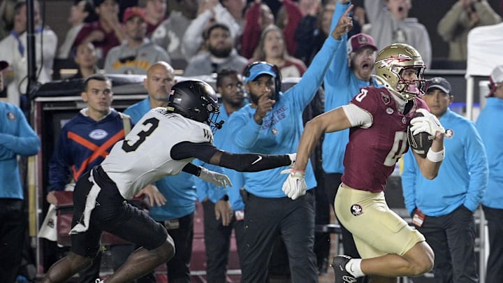 Nov 1, 2025; Tallahassee, Florida, USA; Florida State Seminoles wide receiver Duce Robinson (0) runs with the ball past the defense of Wake Forest Demon Deacons defensive back Karon Prunty (3) during the first quarter at Doak S. Campbell Stadium. Mandatory Credit: Melina Myers-Imagn Images