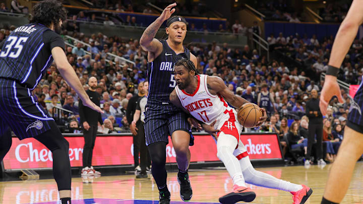 Mar 19, 2025; Orlando, Florida, USA; Houston Rockets forward Tari Eason (17) drives around Orlando Magic forward Paolo Banchero (5) during the second half at Kia Center. Mandatory Credit: Mike Watters-Imagn Images
