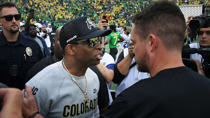 Colorado coach Deion Sanders, left, and Oregon's Dan Lanning meet at midfield after the game in