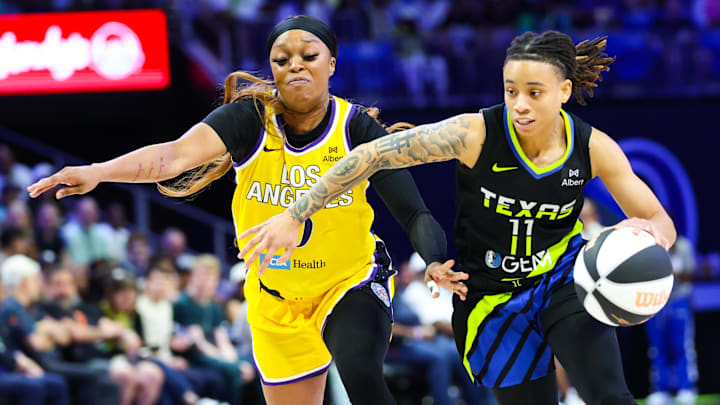 Jun 6, 2025; Arlington, Texas, USA;  Dallas Wings guard JJ Quinerly (11) dribbles past Los Angeles Sparks guard Odyssey Sims (0) during the second half at College Park Center. Mandatory Credit: Kevin Jairaj-Imagn Images