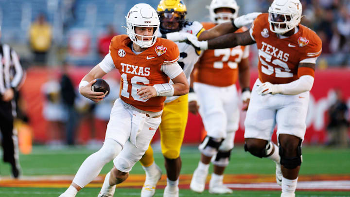 Texas Longhorns quarterback Arch Manning (16) runs with the ball against the Michigan Wolverines