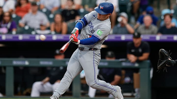Aug 5, 2025; Denver, Colorado, USA; Toronto Blue Jays center fielder Daulton Varsho (5) hits a two run home run in the fourth inning against the Colorado Rockies at Coors Field. 