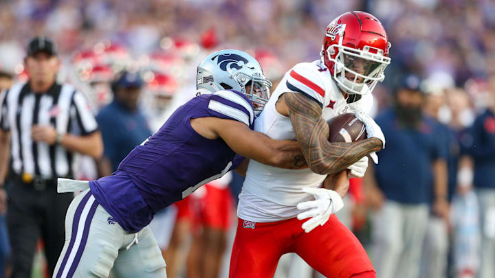 Sep 13, 2024; Manhattan, Kansas, USA; Arizona Wildcats wide receiver Tetairoa McMillan (4) is tackled by Kansas State Wildcats cornerback Keenan Garber (1) during the first quarter at Bill Snyder Family Football Stadium. 