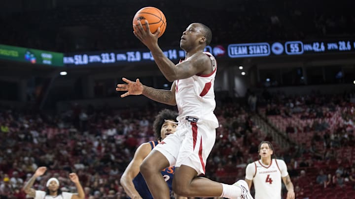 Dec 7, 2024; Fayetteville, Arkansas, USA;  Arkansas Razorbacks guard Johnell Davis (1) goes up for a layup past Texas-San Antonio Roadrunners forward Jaquan Scott (2) during the second half at Bud Walton Arena. Arkansas won 75-60. Mandatory Credit: Brett Rojo-Imagn Images