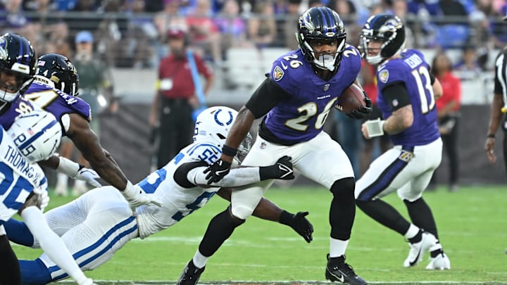 Aug 7, 2025; Baltimore, Maryland, USA; Baltimore Ravens running back Rasheen Ali (26) breaks out of a tackle by Indianapolis Colts defensive end Isaiah Land (55) during the second quarter at M&T Bank Stadium. Mandatory Credit: Rafael Suanes-Imagn Images