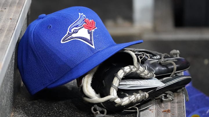 Apr 16, 2025; Toronto, Ontario, CAN; A Toronto Blue Jays hat and glove in the dugout during a game against the Atlanta Braves at Rogers Centre. 