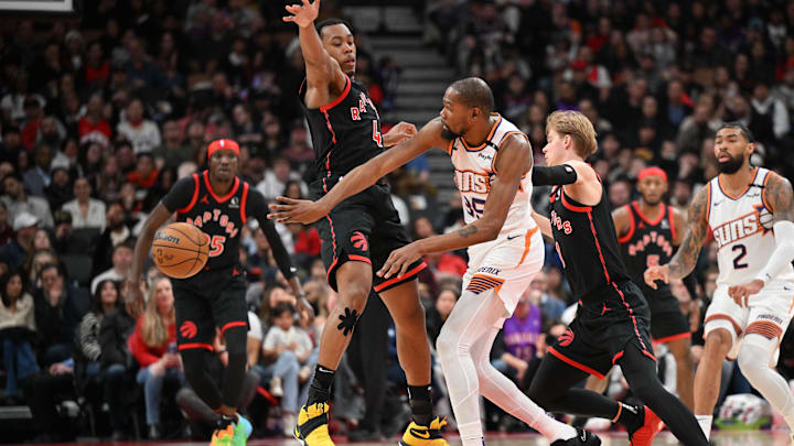 Feb 23, 2025; Toronto, Ontario, CAN;  Phoenix Suns forward Kevin Durant (35) passes the ball past Toronto Raptors forward Scottie Barnes (4) in the first half at Scotiabank Arena. Mandatory Credit: Dan Hamilton-Imagn Images