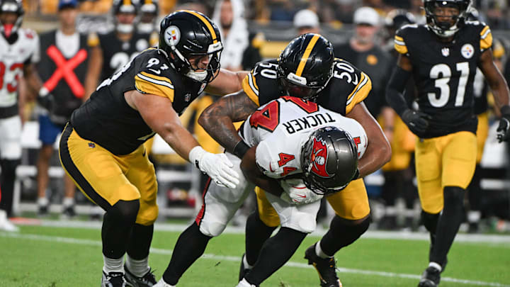 Aug 16, 2025; Pittsburgh, Pennsylvania, USA; Pittsburgh Steelers linebacker Malik Harrison (50) and defensive tackle Logan Lee (91) tackle Tampa Bay Buccaneers running back Sean Tucker (44) during the second half at Acrisure Stadium. Mandatory Credit: Barry Reeger-Imagn Images