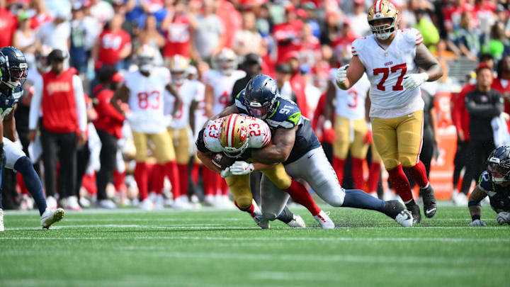 Sep 7, 2025; Seattle, Washington, USA; Seattle Seahawks defensive tackle Byron Murphy II (91) tackles San Francisco 49ers running back Christian McCaffrey (23) during the second half at Lumen Field. Mandatory Credit: Steven Bisig-Imagn Images