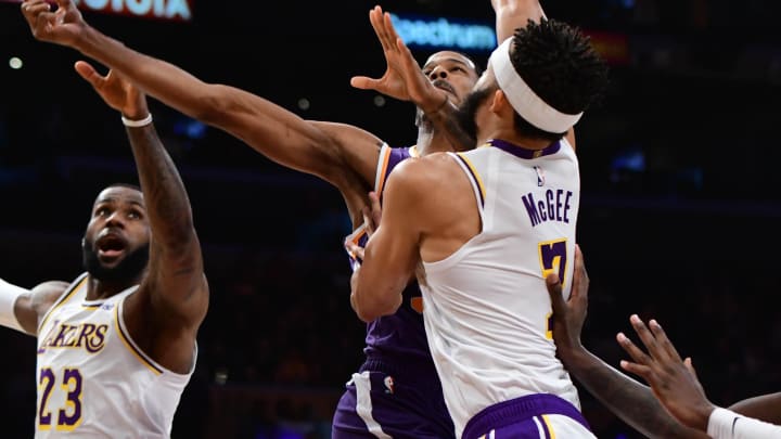 Dec 2, 2018; Los Angeles, CA, USA; Phoenix Suns forward Trevor Ariza (3) puts up a shot between Los Angeles Lakers forward LeBron James (23) and Los Angeles Lakers center JaVale McGee (7) during the first quarter at Staples Center. Mandatory Credit: Robert Hanashiro-USA TODAY Sports
