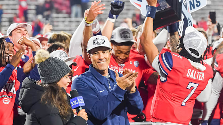 Dec 1, 2023; Lynchburg, VA, USA; Liberty Flames head coach Jamey Chadwell claps as quarterback Kaidon Salter (7) holds the Conference USA championship trophy up after the game against the New Mexico State Aggies at Williams Stadium. Mandatory Credit: Brian Bishop-USA TODAY Sports