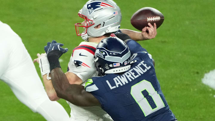 Feb 8, 2026; Santa Clara, CA, USA; New England Patriots quarterback Drake Maye (10) is hit as he throws by Seattle Seahawks defensive end DeMarcus Lawrence (0) in the second half in Super Bowl LX at Levi's Stadium. 