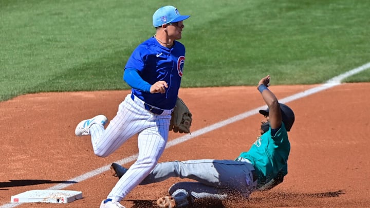 Mar 8, 2024; Mesa, Arizona, USA;  Seattle Mariners shortstop Ryan Bliss (1) slides into third base as Chicago Cubs third baseman Matt Shaw (77) defends in the second inning during a spring training game at Sloan Park.