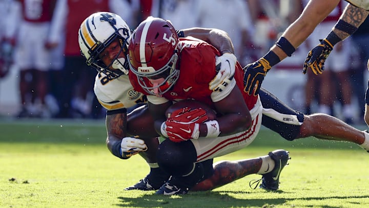Oct 26, 2024; Tuscaloosa, Alabama, USA;  Alabama Crimson Tide wide receiver Germie Bernard (5) catches a pass as he is tackled by Missouri Tigers safety Joseph Charleston (28) during the first half at Bryant-Denny Stadium. Mandatory Credit: Butch Dill-Imagn Images