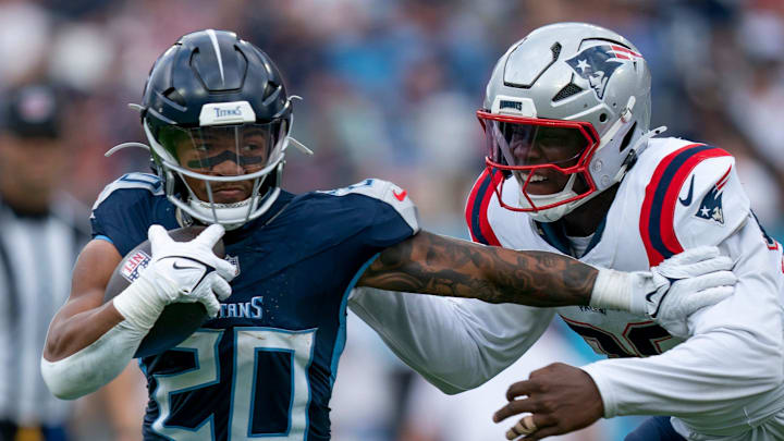 Tennessee Titans running back Tony Pollard (20) holds off New England Patriots defensive end Keion White (99) during their game at Nissan Stadium in Nashville, Tenn., Sunday, Nov. 3, 2024. White brought down Pollard, but was called for a horse-collar tackle penalty.