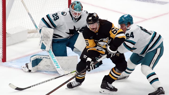 Nov 16, 2024; Pittsburgh, Pennsylvania, USA;  San Jose Sharks goaltender Mackenzie Blackwood (29) and center Mikael Granlund (64) defend Pittsburgh Penguins defenseman Erik Karlsson (65) in overtime at PPG Paints Arena. Mandatory Credit: Charles LeClaire-Imagn Images