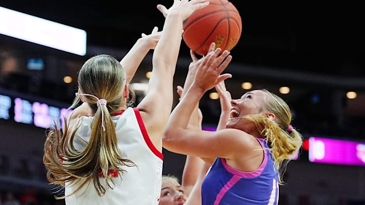 Norwalk forward Ava Carlson (11) shoots the ball around Dallas Center-Grimes forward Ava Smid (12) during the first quarter the 4A high school girls state basketball semi-final on March 5, 2026, at Casey’s Center in Des Moines, Iowa.