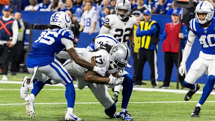 Dec 31, 2023; Indianapolis, Indiana, USA; Las Vegas Raiders wide receiver Davante Adams (17) runs after a catch while Indianapolis Colts linebacker Grant Stuard (41) and cornerback Chris Lammons (35) defend in the second half at Lucas Oil Stadium.