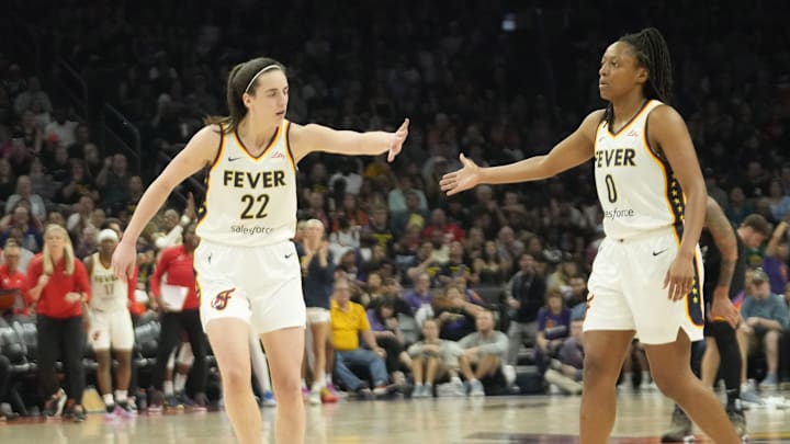 Jun 30, 2024; Phoenix, Ariz., U.S.; Indiana Fever guard Caitlin Clark (22) slaps hands with guard Kelsey Mitchell (0) during the third quarter against the Phoenix Mercury at Footprint Center. Mandatory Credit: Michael Chow-Arizona Republic