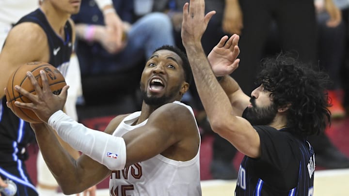 Mar 16, 2025; Cleveland, Ohio, USA; Cleveland Cavaliers guard Donovan Mitchell (45) drives to the basket beside Orlando Magic center Goga Bitadze (35) in the third quarter at Rocket Arena. Mandatory Credit: David Richard-Imagn Images