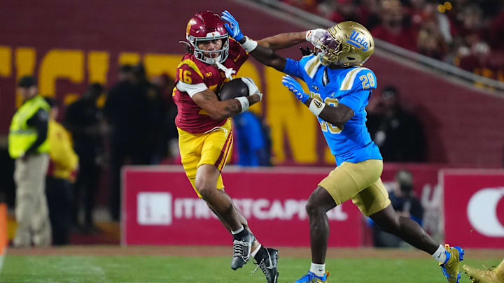 Nov 29, 2025; Los Angeles, California, USA; Southern California Trojans wide receiver Tanook Hines (16) carries the ball against UCLA Bruins defensive back Scooter Jackson (28) in the first half at United Airlines Field at Los Angeles Memorial Coliseum. Mandatory Credit: Kirby Lee-Imagn Images