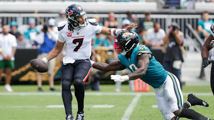 Sep 21, 2025; Jacksonville, Florida, USA; Houston Texans quarterback C.J. Stroud (7) attempts to evade a tackle by Jacksonville Jaguars linebacker Devin Lloyd (0) during the second quarter at EverBank Stadium. Mandatory Credit: Travis Register-Imagn Images