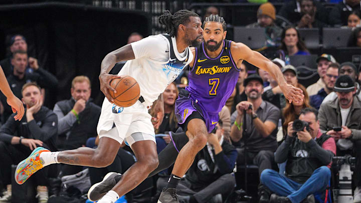 Dec 2, 2024; Minneapolis, Minnesota, USA; Minnesota Timberwolves center Naz Reid (11) dribbles against the Los Angeles Lakers guard Gabe Vincent (7) in the second quarter at Target Center.