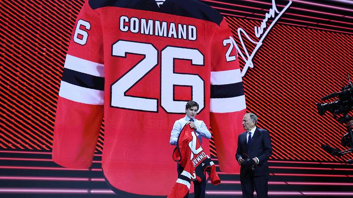 Alexander Command reacts beside NHL commissioner Gary Bettman after being selected with the twelfth pick in the first round of the 2026 NHL Draft by the New Jersey Devils at KeyBank Center. Mandatory Credit: Timothy T. Ludwig-Imagn Images