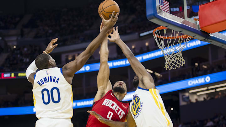 Dec 5, 2024; San Francisco, California, USA;  Golden State Warriors forward Jonathan Kuminga (00) and forward Andrew Wiggins (22) defend against Houston Rockets forward Dillon Brooks (9) during the third quarter at Chase Center. Mandatory Credit: John Hefti-Imagn Images