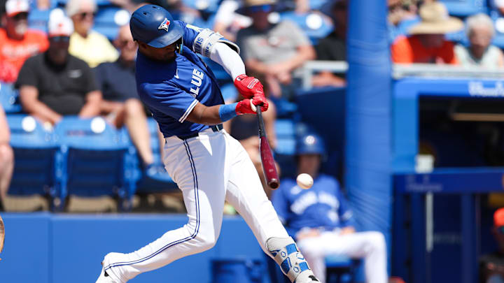 Mar 13, 2025; Dunedin, Florida, USA; Toronto Blue Jays second baseman Orelvis Martinez (13) hits a base hit against the Baltimore Orioles in the second inning during spring training at TD Ballpark. 