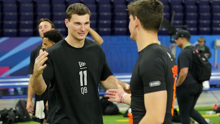 Feb 28, 2026; Indianapolis, IN, USA; Indiana quarterback Fernando Mendoza (QB11) greets Alabama quarterback Ty Simpson (QB17) during the NFL Scouting Combine at Lucas Oil Stadium. 