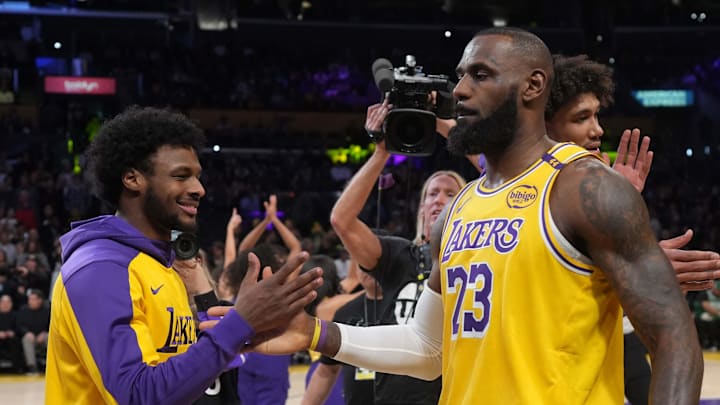 Los Angeles Lakers forward LeBron James (23) interacts with son Bronny James during the game against the Boston Celtics at the Crypto.com Arena.