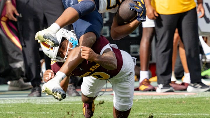 Arizona State Sun Devils Rodney Bimage Jr. (0) tackles West Virginia Mountaineers Cyncir Bowers (23) during a game at Mountain America Stadium in Tempe on Nov. 15, 2025. Arizona State Sun Devils Rodney Bimage Jr. (0) tackles West Virginia Mountaineers Cyncir Bowers (23) during a game at Mountain America Stadium in Tempe on Nov. 15, 2025.