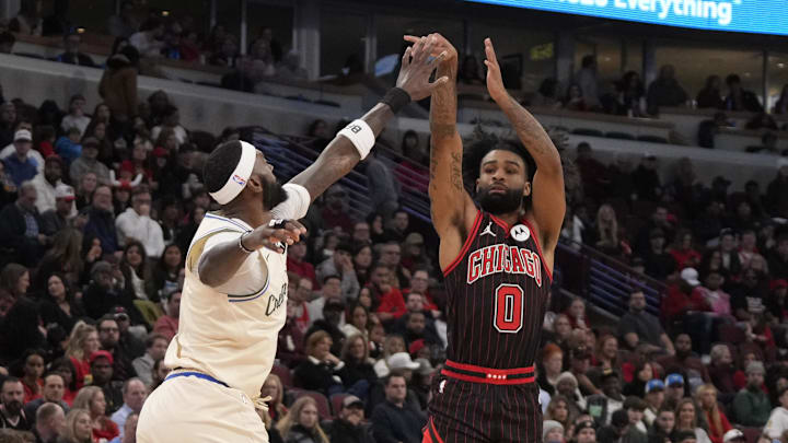 Dec 27, 2025; Chicago, Illinois, USA; Chicago Bulls guard Coby White (0) shoots over Milwaukee Bucks forward Bobby Portis (9) during the first half at United Center. Mandatory Credit: David Banks-Imagn Images