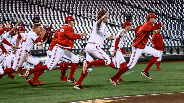 The Husker dugout runs out to meet Robby Bolin after his walk-off single. 