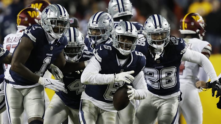 Dallas Cowboys safety Donovan Wilson celebrates with teammates after intercepting a pass against the Washington Commanders.