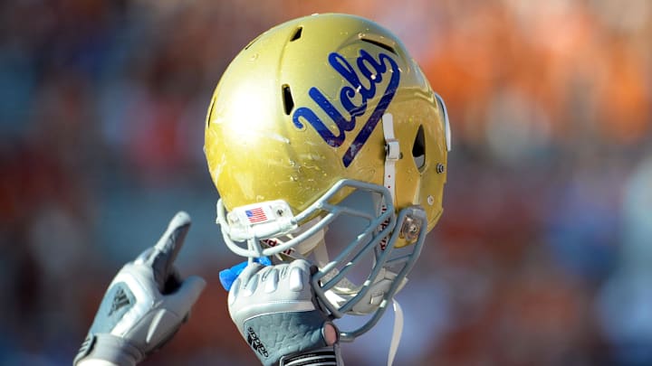 Sept 25, 2010; Austin, TX, USA; A member of the UCLA Bruins holds up his helmet to acknowledge their fans against the Texas Longhorns during the fourth quarter at Texas Memorial Stadium. UCLA beat Texas 34-12. Mandatory Credit: Brendan Maloney-Imagn Images Sept 25, 2010; Austin, TX, USA; A member of the UCLA Bruins holds up his helmet to acknowledge their fans against the Texas Longhorns during the fourth quarter at Texas Memorial Stadium. UCLA beat Texas 34-12. Mandatory Credit: Brendan Maloney-Imagn Images