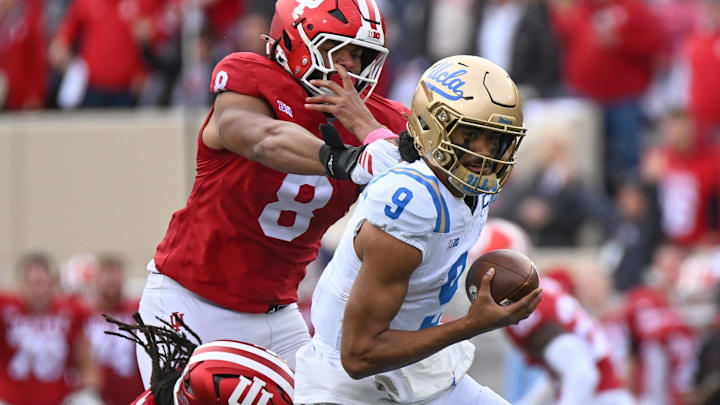 Oct 25, 2025; Bloomington, Indiana, USA; UCLA Bruins quarterback Nico Iamaleava (9) runs with the ball against Indiana Hoosiers defensive lineman Stephen Daley (8) during the second half at Memorial Stadium. Mandatory Credit: Robert Goddin-Imagn Images