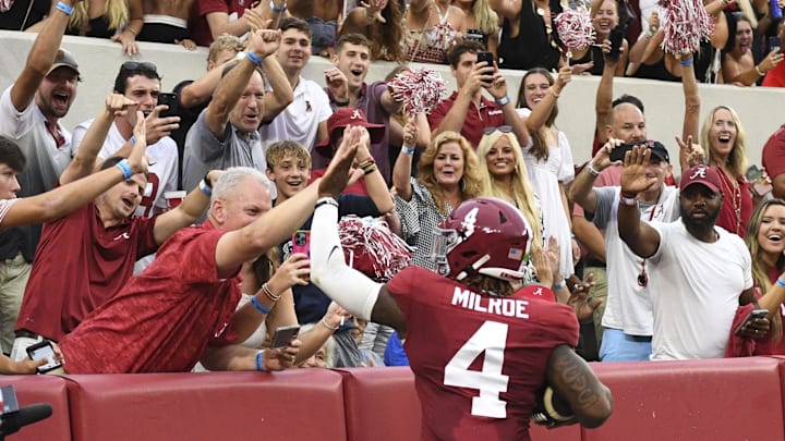 Aug 31, 2024; Tuscaloosa, Alabama, USA;  Alabama Crimson Tide quarterback Jalen Milroe (4) celebrates with fans after scoring against the Western Kentucky Hilltoppers during the first half at Bryant-Denny Stadium.  Mandatory Credit: Gary Cosby Jr.-Imagn Images