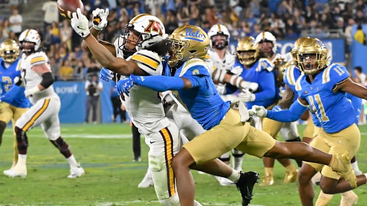Oct 12, 2024; Pasadena, California, USA; Minnesota Golden Gophers wide receiver Elijah Spencer (11) reaches for the ball as he is hit by UCLA Bruins defensive back Kaylin Moore (9) in the third quarter at Rose Bowl. Moore was called for pass interference on the play. Mandatory Credit: Robert Hanashiro-Imagn Images