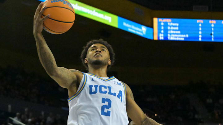Jan 24, 2026; Los Angeles, California, USA; UCLA Bruins guard Donovan Dent (2) drives up for a basket past Northwestern Wildcats guard Jordan Clayton (11) in the first half at Pauley Pavilion presented by Wescom Financial. Mandatory Credit: Jayne Kamin-Oncea-Imagn Images